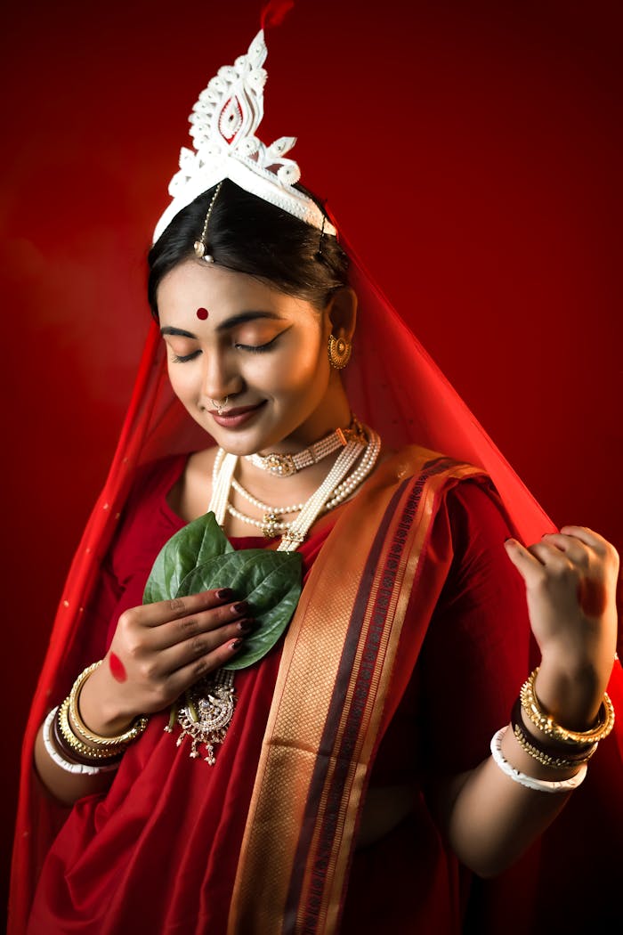 A graceful woman in traditional Indian attire holding a betel leaf, symbolizing cultural elegance.