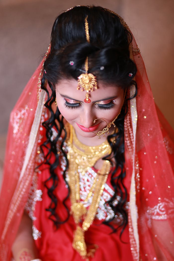 A beautiful Indian bride in traditional attire and jewelry, captured in a close-up portrait.