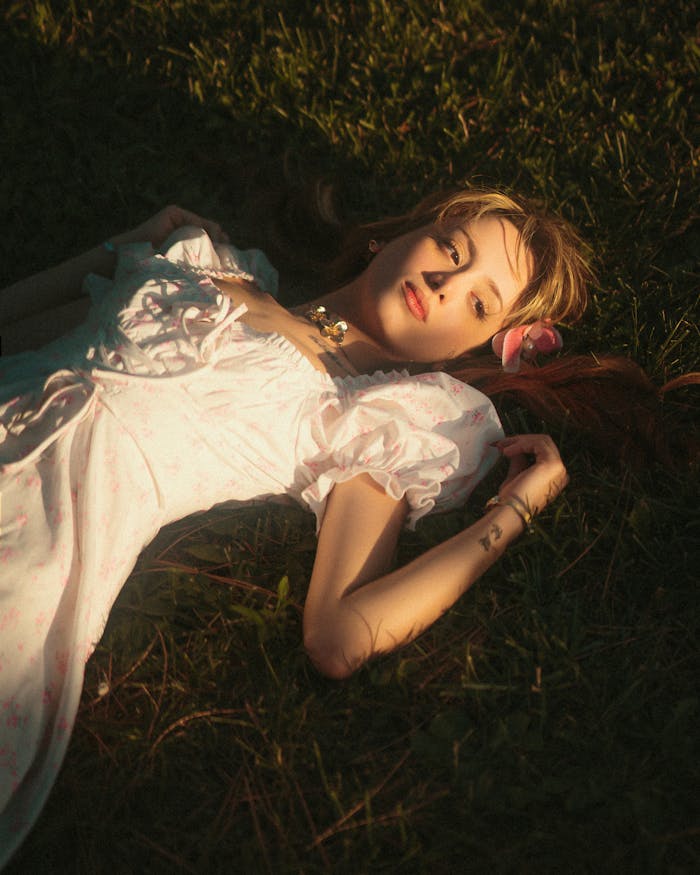 young-woman-in-vintage-dress-lying-on-grass-33965214
